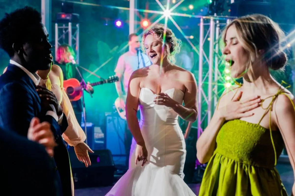 La mariée danse avec ses amies devant le groupe