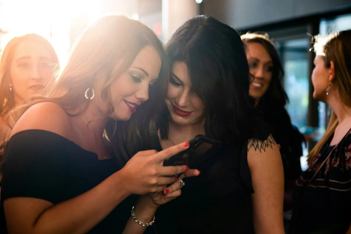 Deux amies éclatent de rire devant un téléphone
