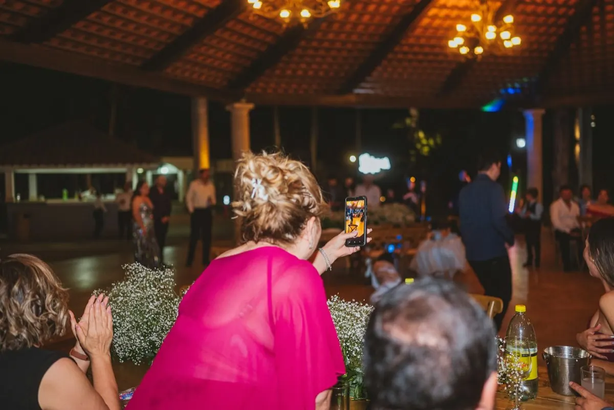 Une invitée lève son téléphone pendant la soirée